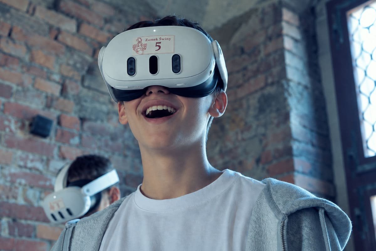 Gość zakłada gogle VR w komnacie Zamku Świny