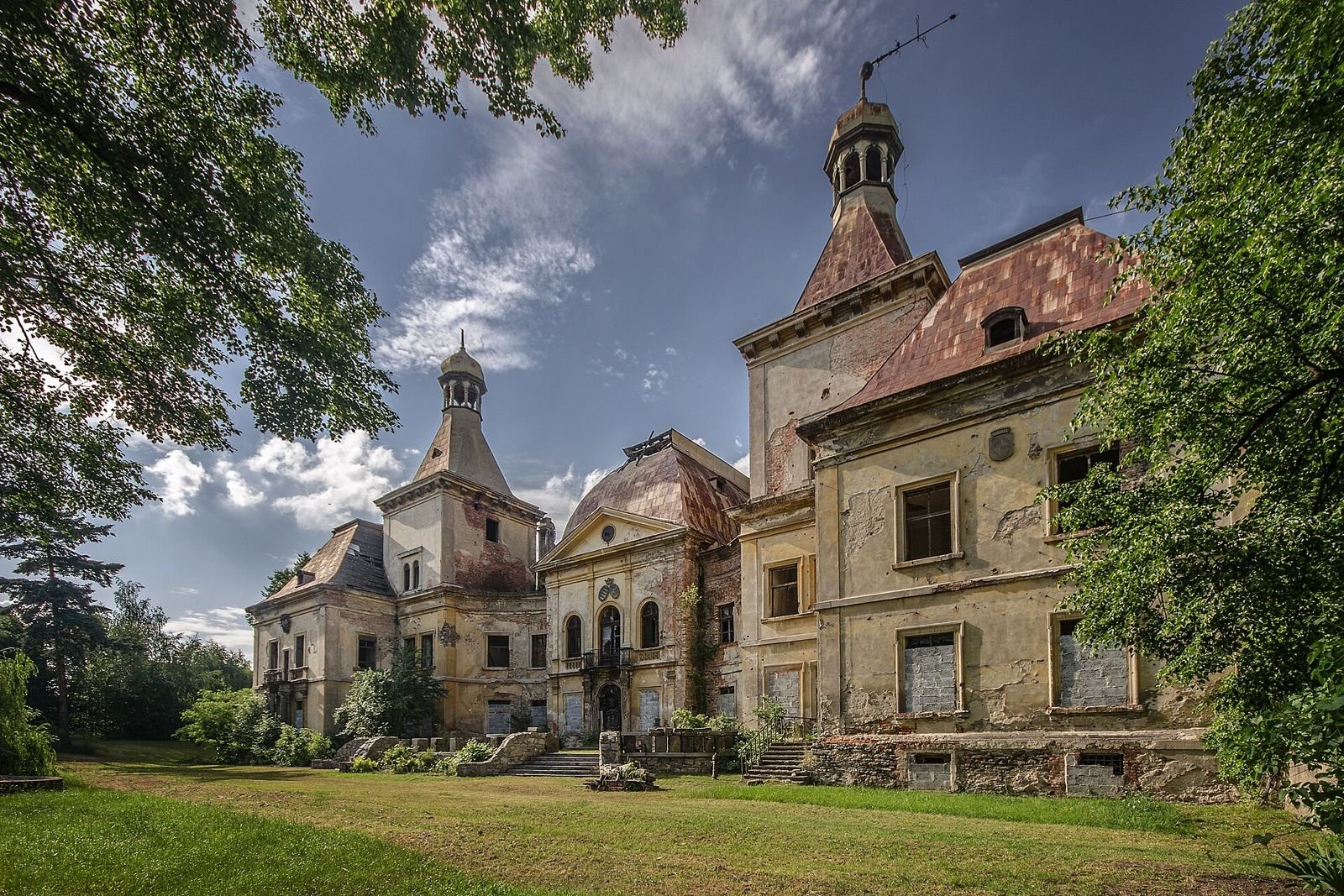 Narożnik pałacu w Mańczycach z wieżami, schodami i wejściem w środkowym ryzalicie.