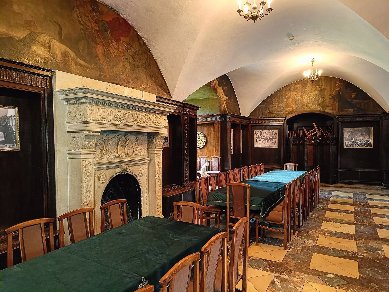 Sala w Zamku Czocha z marmurową posadzką, rzeźbionym kominkiem i malowidłami na sklepieniu