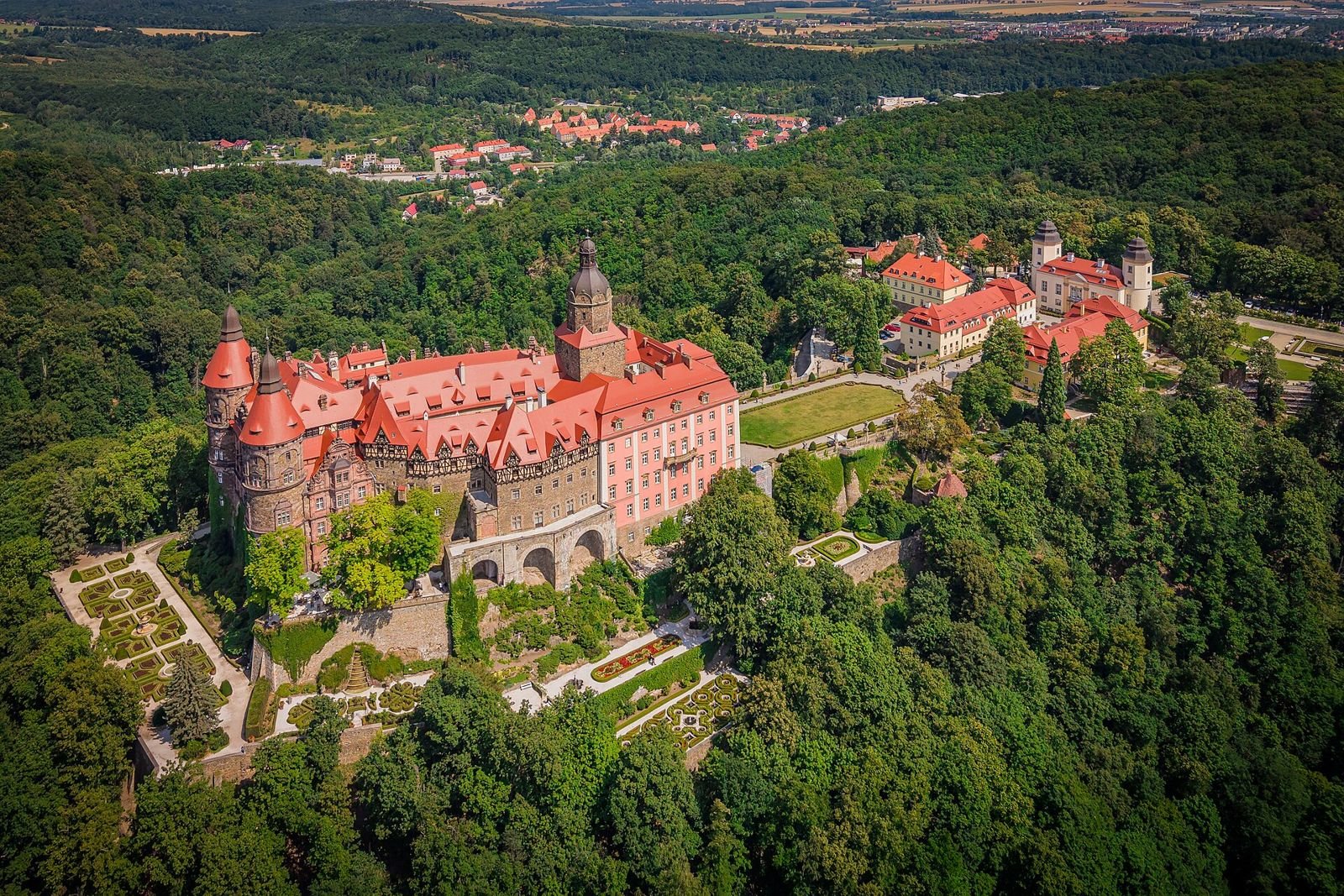 Zamek Książ z lotu ptaka: zamek na skalnym cyplu, tarasy poniżej i las dookoła