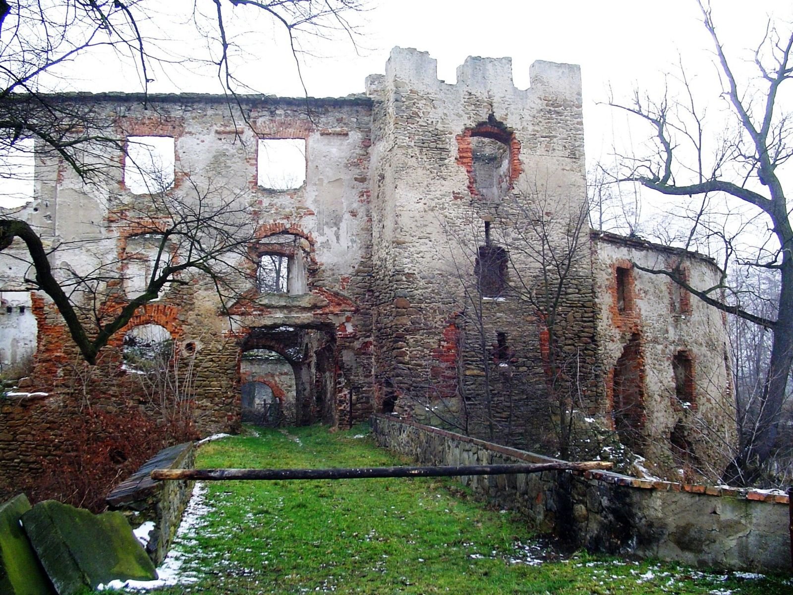 Ruina wieży bramnej z blankami i przejściem, widok od strony dziedzińca.