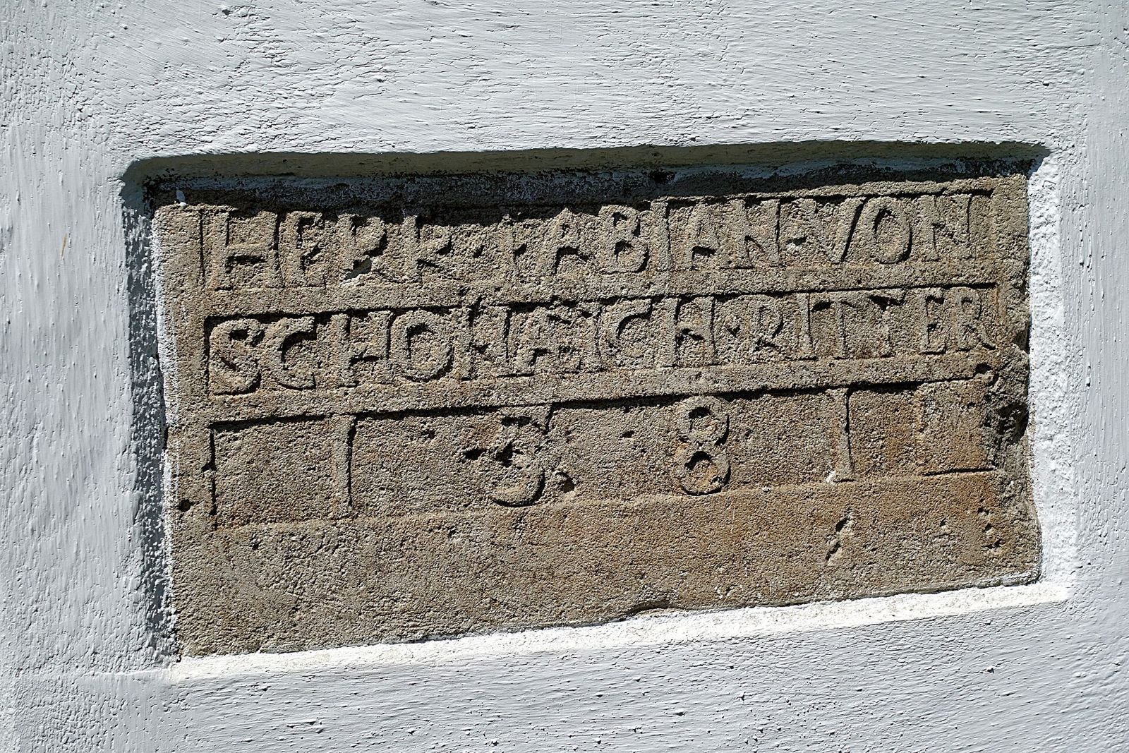 Kamienna płycina z napisem wmurowana w ścianę zamku w Prochowicach.