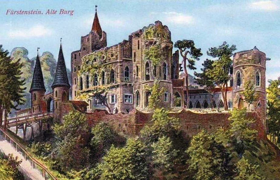 Dawna pocztówka z podpisem „Fürstenstein, Alte Burg” z kolorowym widokiem zamku z wieżyczkami na zalesionym wzgórzu.